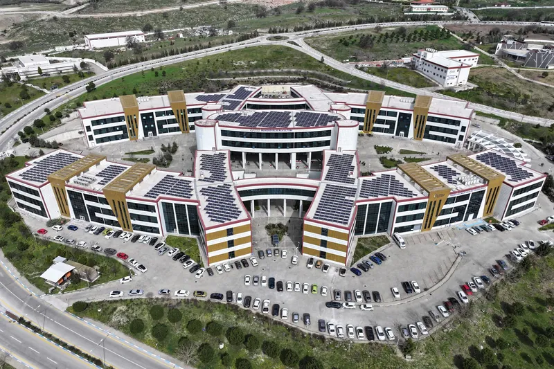 Çatıları güneş panelleriyle kaplı bir MCBÜ fakülte binası, havadan